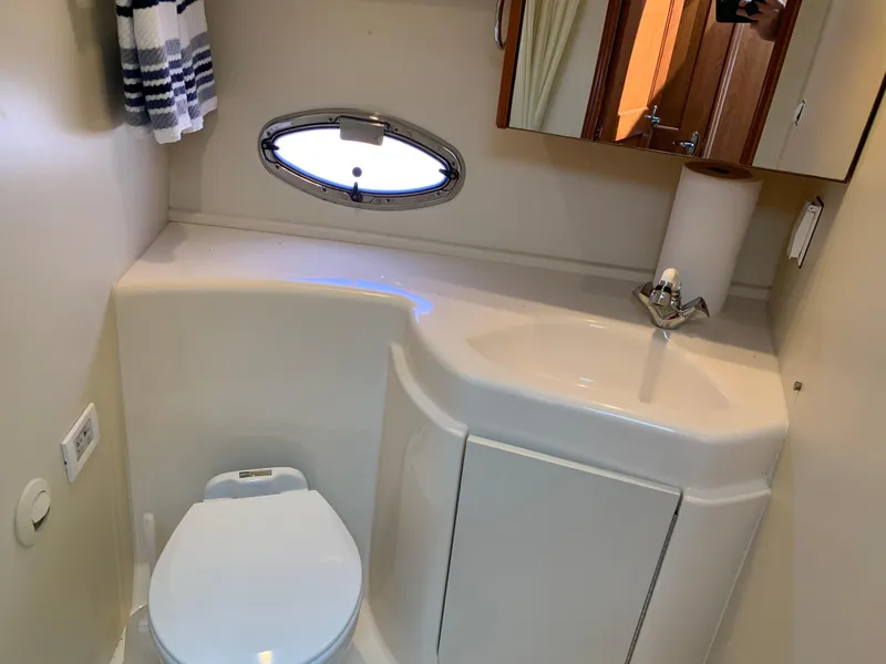 Slide: The Image of Bathroom interior of 2012 Silverton 33 Sport Coupe with sink, toilet, and porthole window. - 43