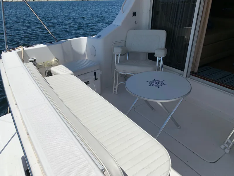 Slide: The Image of 2012 Silverton 33 Sport Coupe boat interior with white seating and nautical-themed table. - 6