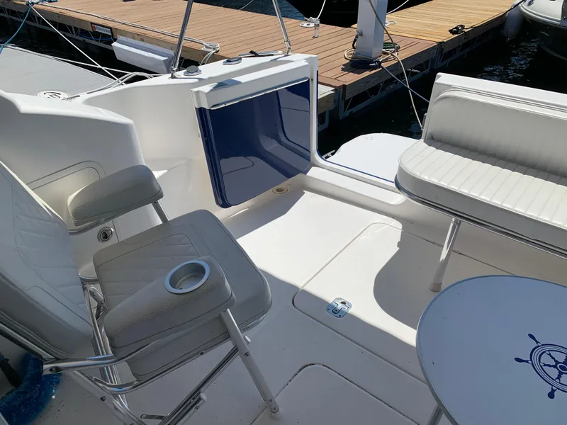 Slide: The Image of 2012 Silverton 33 Sport Coupe boat interior with seating and table, docked at marina. - 7