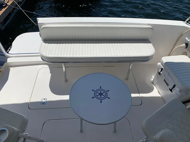 Slide: The Image of 2012 Silverton 33 Sport Coupe boat interior with white seating and nautical-themed table. - 9