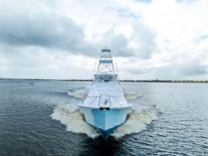 Slide: The Image of Front view of a 2004 Bertram 570 yacht cruising on open water under cloudy skies. - 10