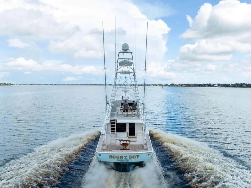 Slide: The Image of 2004 Bertram 570 yacht cruising on open water under a partly cloudy sky. - 11