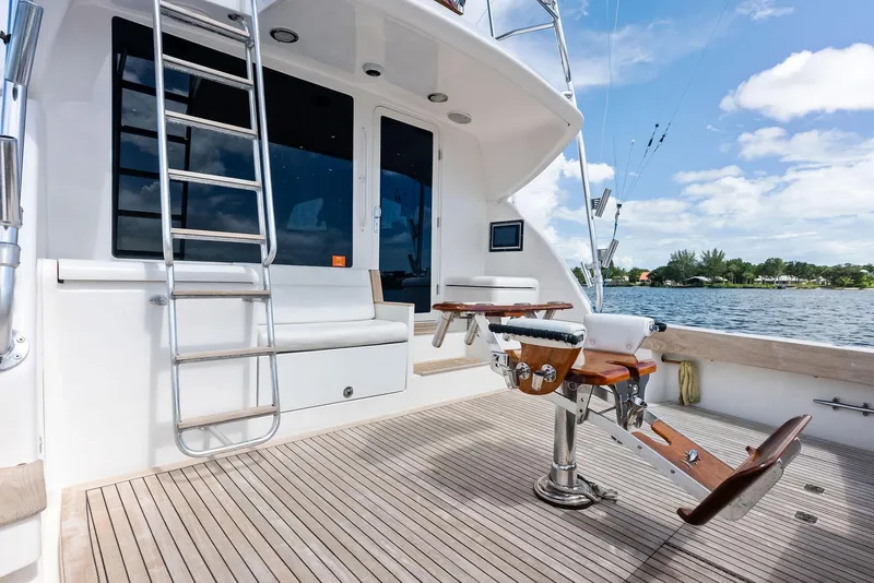 Slide: The Image of 2004 Bertram 570 yacht deck with fishing chair, ladder, and scenic water view. - 15