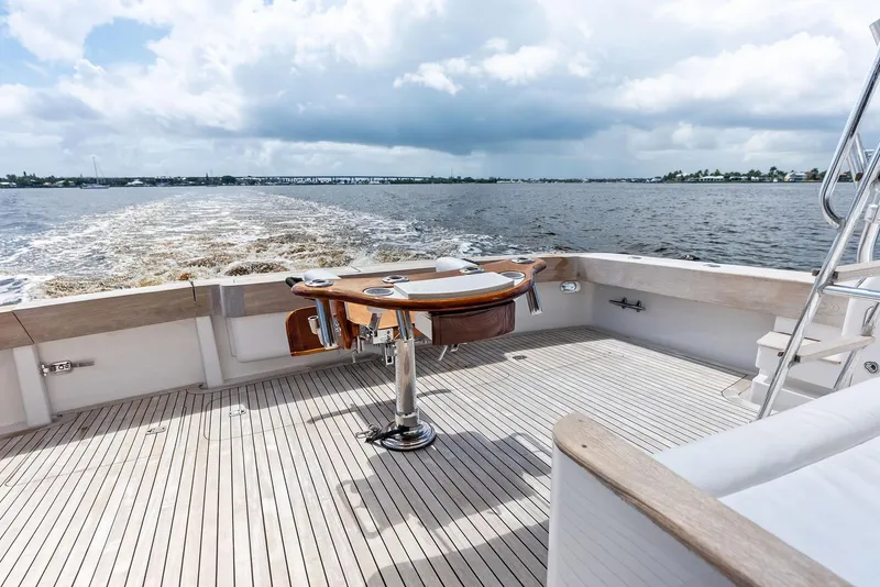 Slide: The Image of 2004 Bertram 570 yacht deck with fishing chair, ocean view, and cloudy sky. - 16