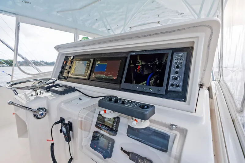 Slide: The Image of Control panel of a 2004 Bertram 570 yacht with navigation screens and steering wheel. - 21