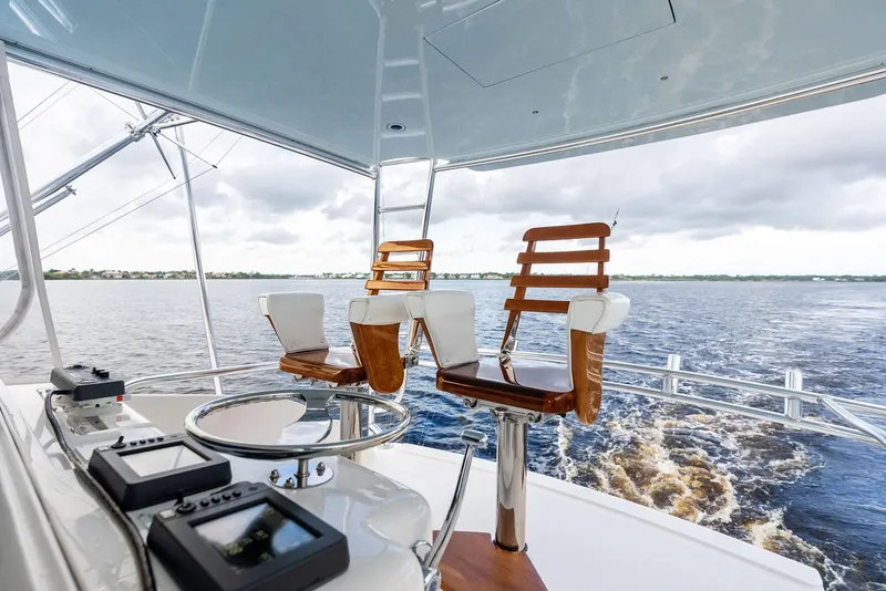 Slide: The Image of Luxury yacht helm with wooden chairs, Bertram 570, 2004 model, cruising on open water. - 24