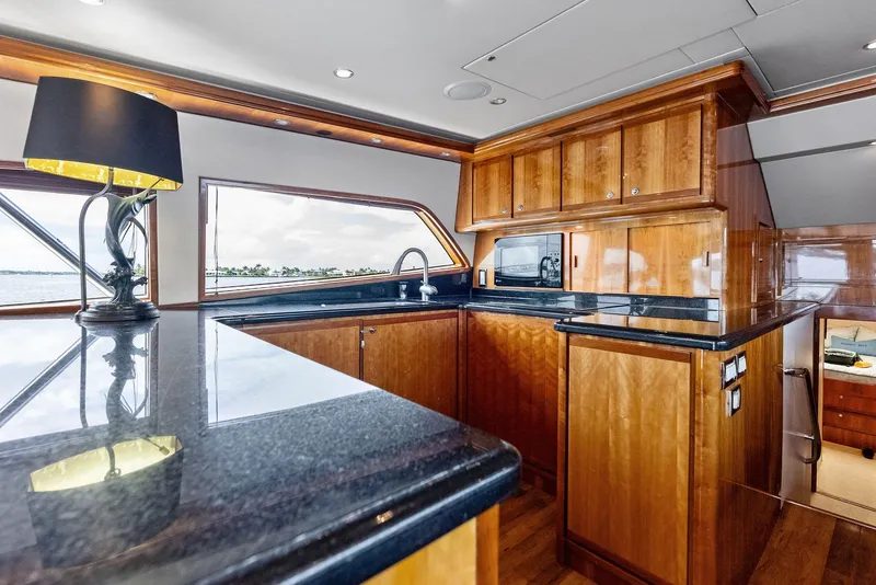 Slide: The Image of Luxurious kitchen interior of 2004 Bertram 570 yacht with wooden cabinetry and modern appliances. - 29