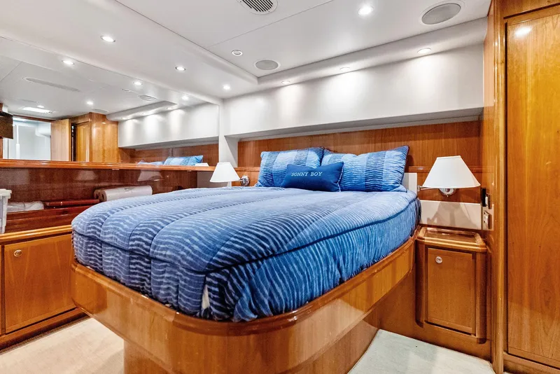 Slide: The Image of Luxurious cabin interior of a 2004 Bertram 570 yacht with blue bedding and wooden finishes. - 33