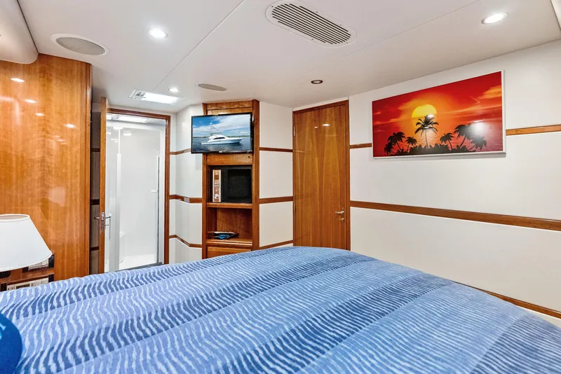 Slide: The Image of Luxurious 2004 Bertram 570 yacht bedroom with modern decor and vibrant sunset artwork. - 34