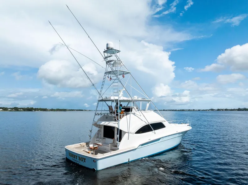 Slide: The Image of 2004 Bertram 570 yacht on calm waters under a clear blue sky. - 4