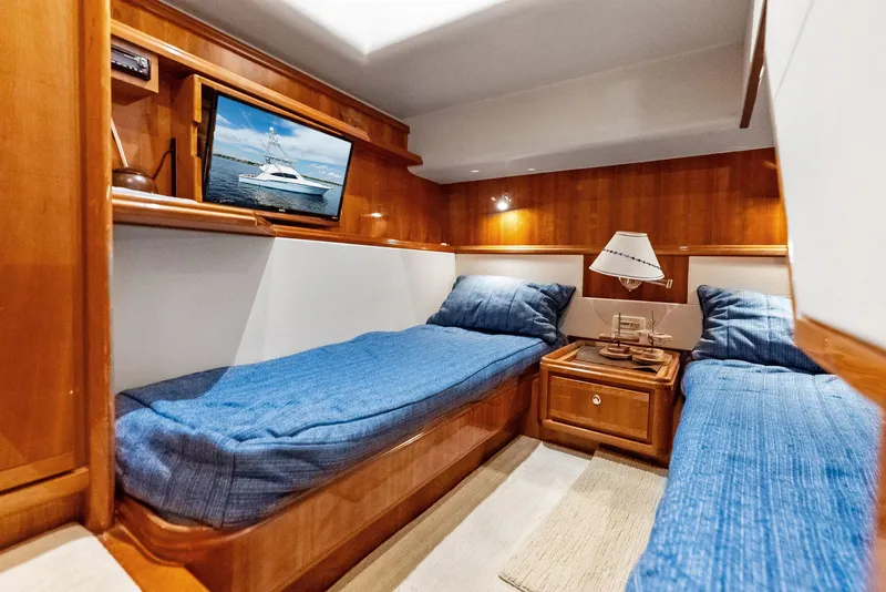 Slide: The Image of Luxurious cabin interior of a 2004 Bertram 570 yacht with twin beds and wooden furnishings. - 42