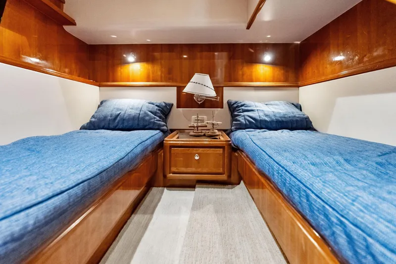 Slide: The Image of Luxurious twin cabin in 2004 Bertram 570 yacht with blue bedding and wooden finishes. - 43
