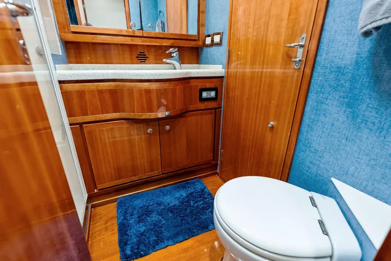 Slide: The Image of Luxurious 2004 Bertram 570 yacht bathroom with wooden cabinetry and modern fixtures. - 45