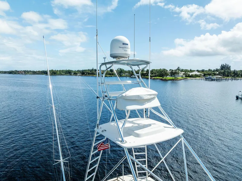 Slide: The Image of 2004 Bertram 570 yacht tower with radar, overlooking serene water and lush shoreline. - 8