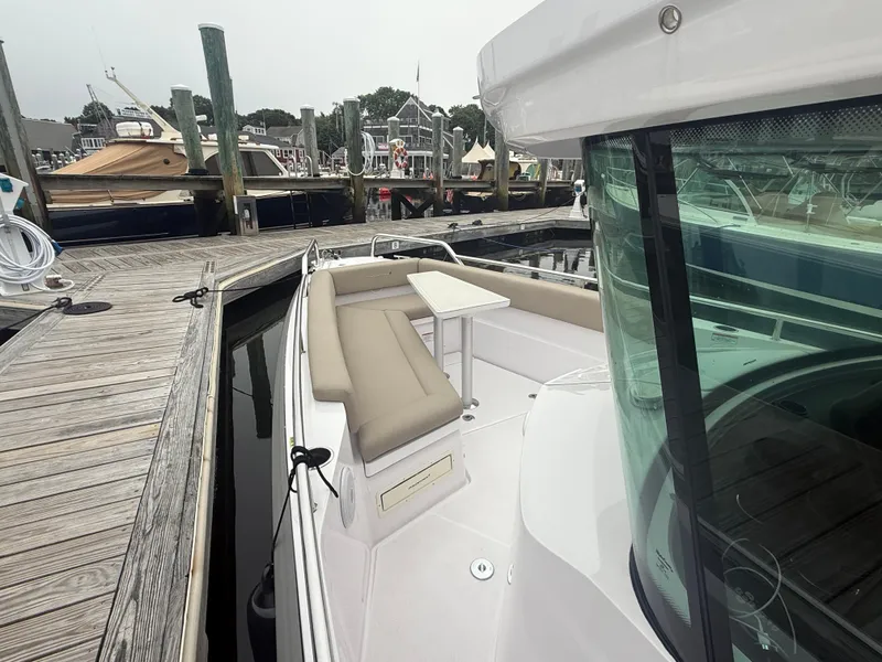 Slide: The Image of 2023 Axopar 28 CABIN boat docked, featuring sleek design and comfortable seating. - 10