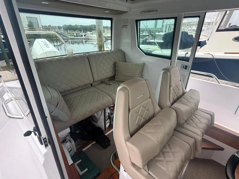 Slide: The Image of Interior of 2023 Axopar 28 CABIN with beige seating and large windows. - 16