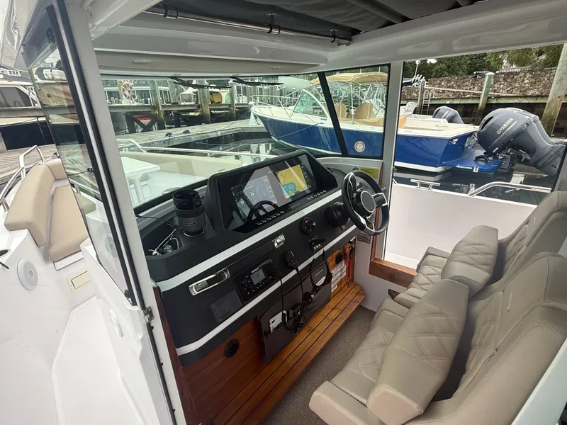 Slide: The Image of 2023 Axopar 28 CABIN interior with modern dashboard and comfortable seating. - 17