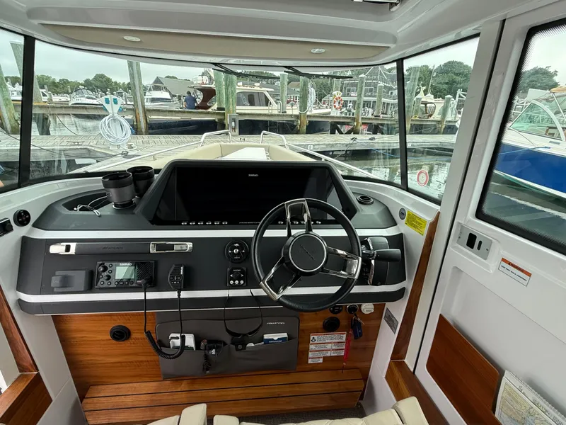 Slide: The Image of Interior view of 2023 Axopar 28 CABIN boat cockpit with steering wheel and control panel. - 18