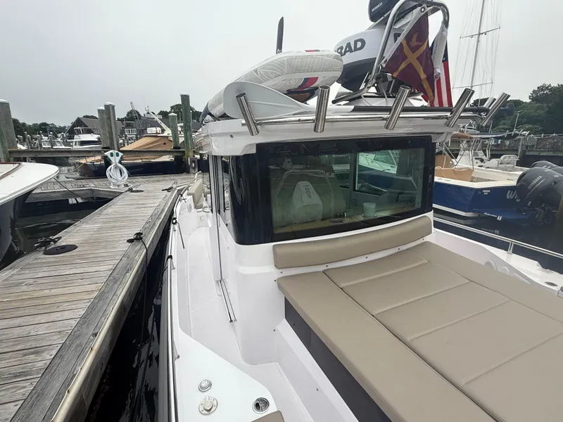 Slide: The Image of 2023 Axopar 28 CABIN boat docked at marina, featuring sleek design and comfortable seating. - 5