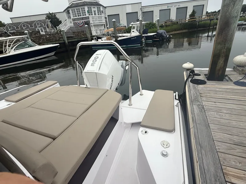 Slide: The Image of 2023 Axopar 28 CABIN boat docked, featuring a spacious seating area and Mercury engine. - 8