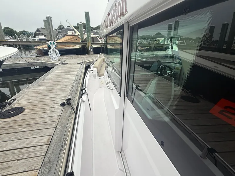 Slide: The Image of 2023 Axopar 28 CABIN docked at a marina, showcasing sleek design and modern features. - 9