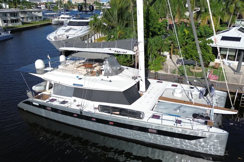 The Image of Luxury Sunreef 62 catamaran yacht docked, 2011 model, surrounded by lush greenery. - 0