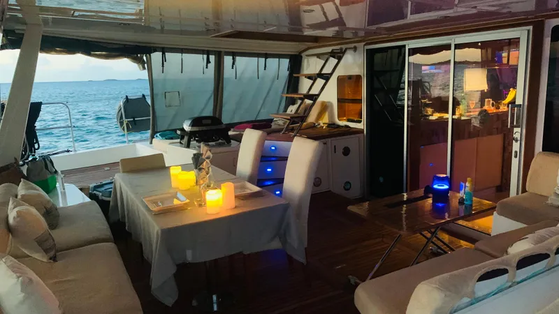 Slide: The Image of Luxurious Sunreef 62 yacht interior with cozy seating, dining area, and ocean view at sunset. - 12
