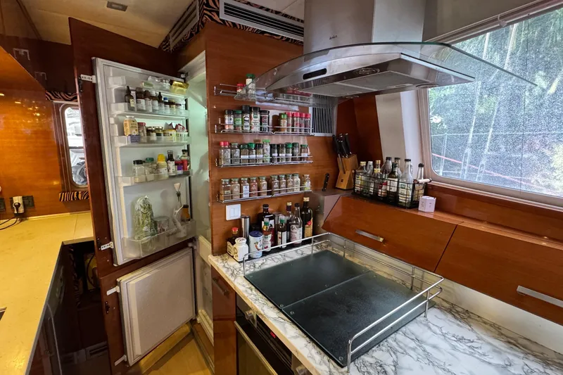 Slide: The Image of Luxurious Sunreef 62 yacht kitchen with open fridge, spice rack, and marble countertop, 2011 model. - 16