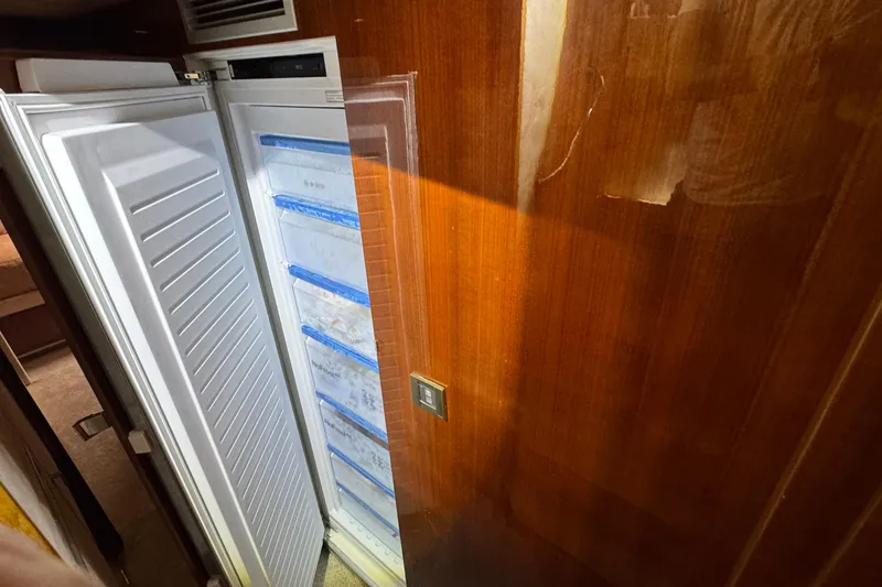 Slide: The Image of Open refrigerator on 2011 Sunreef 62 yacht, wooden interior, showing organized storage. - 17