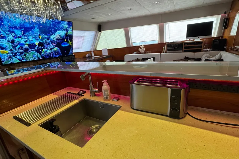 Slide: The Image of Luxurious Sunreef 62 yacht interior with modern kitchen, sink, toaster, and vibrant aquarium display. - 19