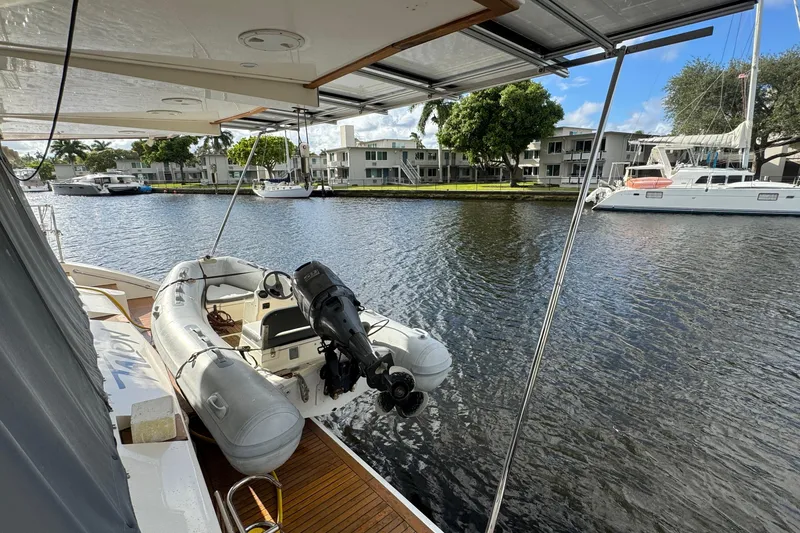 Slide: The Image of 2011 Sunreef 62 yacht with dinghy on calm water, residential backdrop. - 48