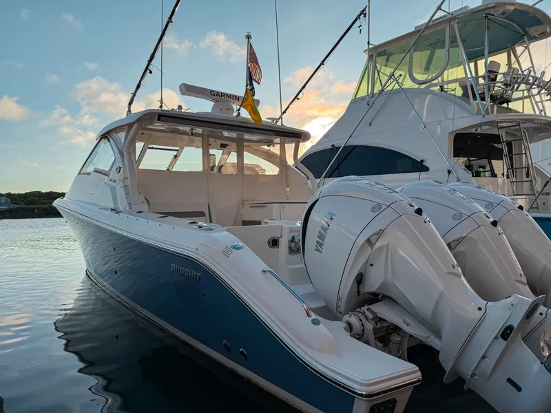 The Image of 2022 Pursuit DC 365 Dual Console boat docked with Yamaha engines at sunset. - 0