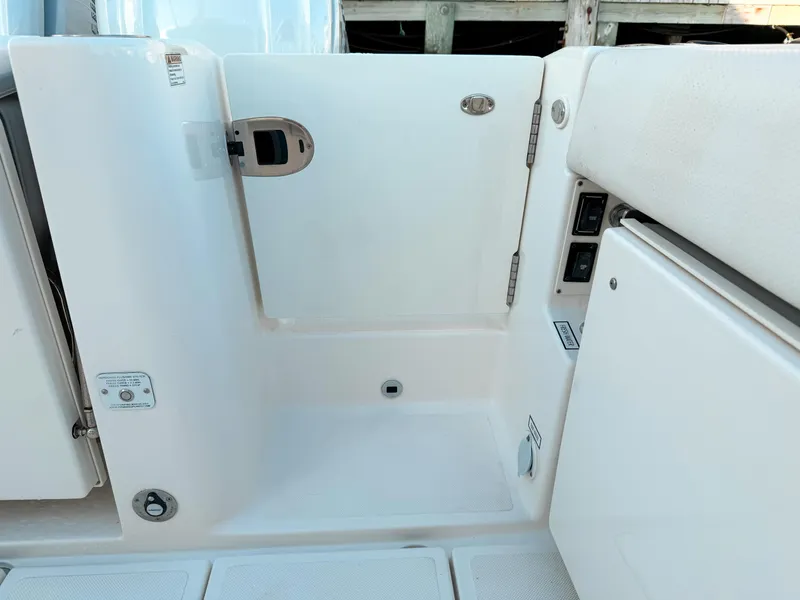 Slide: The Image of 2022 Pursuit DC 365 Dual Console boat interior, featuring a white access door and seating area. - 11
