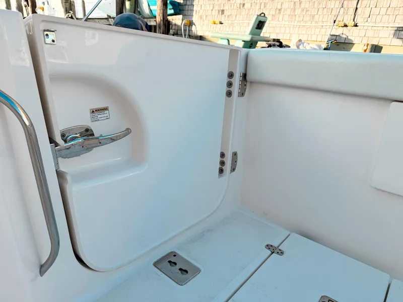 Slide: The Image of 2022 Pursuit DC 365 Dual Console boat interior with open hatch and safety warning. - 14