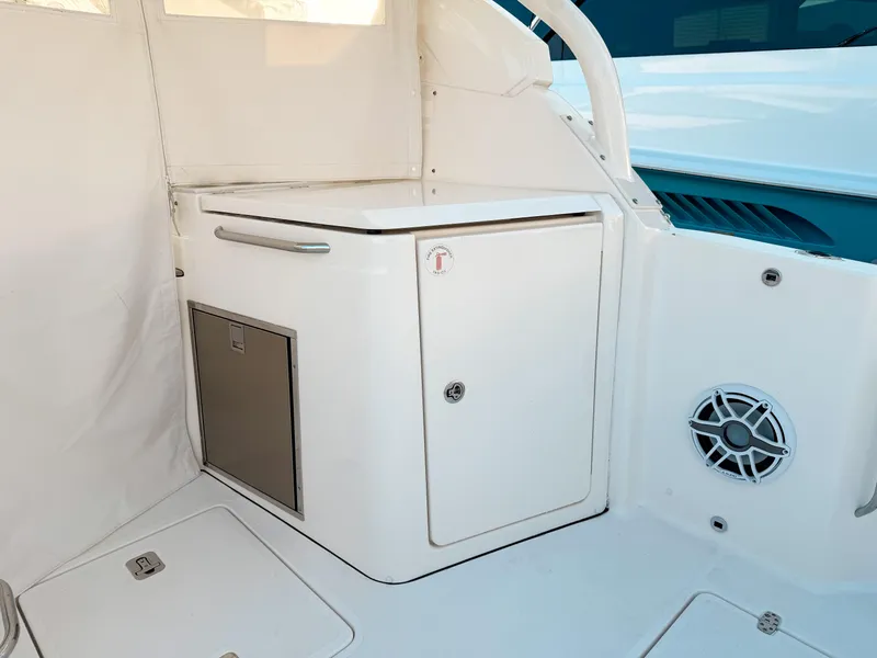 Slide: The Image of 2022 Pursuit DC 365 Dual Console interior with storage compartment and speaker. - 17
