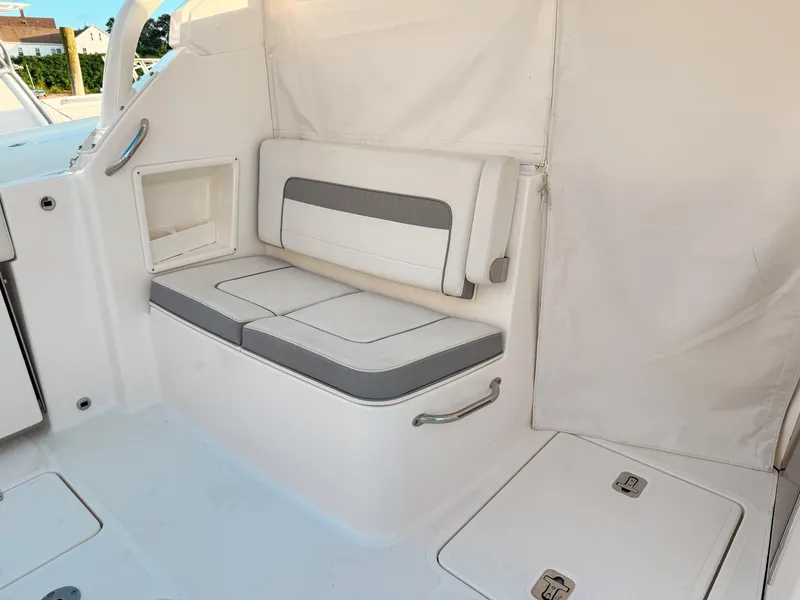 Slide: The Image of 2022 Pursuit DC 365 Dual Console interior seating area with white and gray cushions. - 22