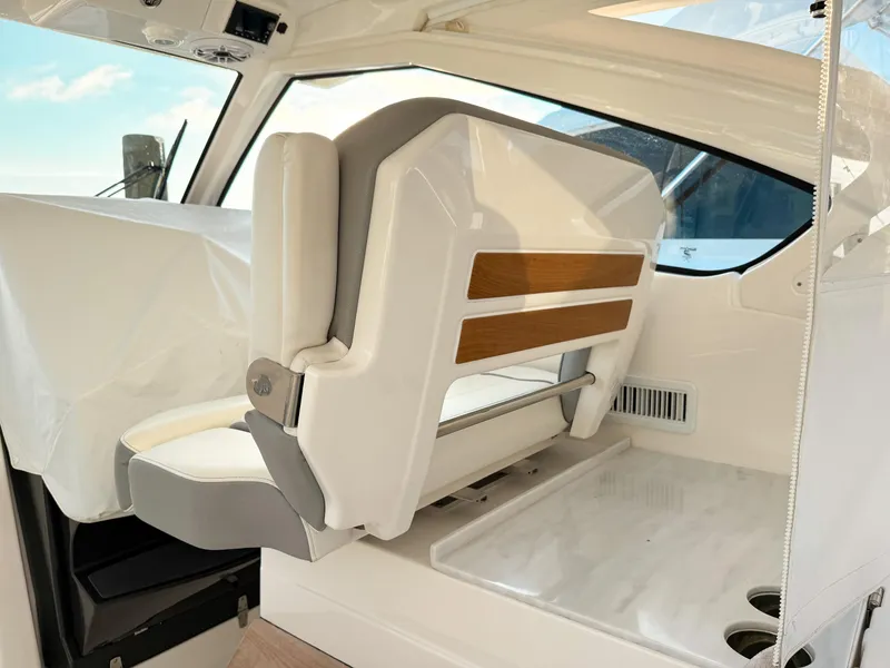 Slide: The Image of 2022 Pursuit DC 365 Dual Console interior with white seating and wood accents. - 25