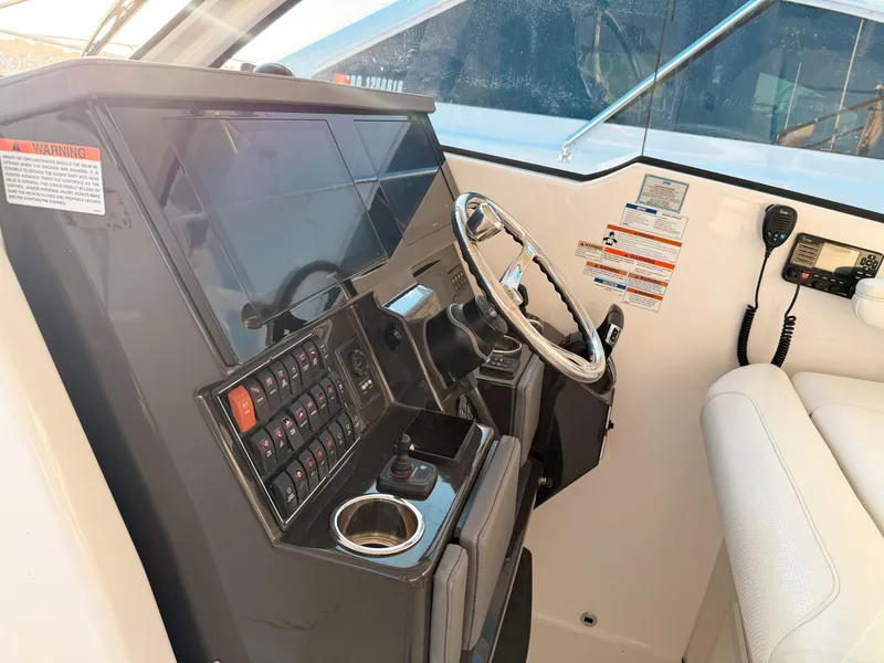 Slide: The Image of 2022 Pursuit DC 365 Dual Console boat cockpit with steering wheel and control panel. - 27
