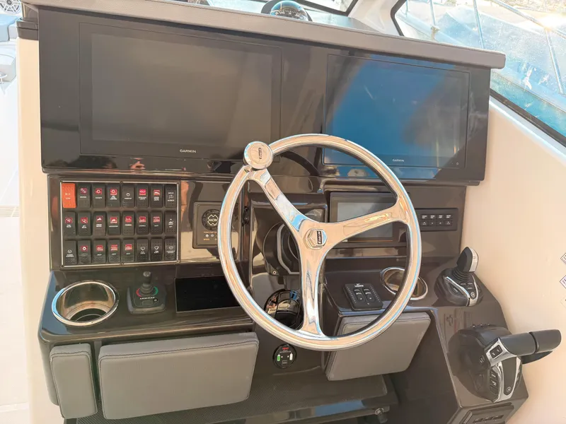 Slide: The Image of 2022 Pursuit DC 365 Dual Console helm with steering wheel and control panel. - 28