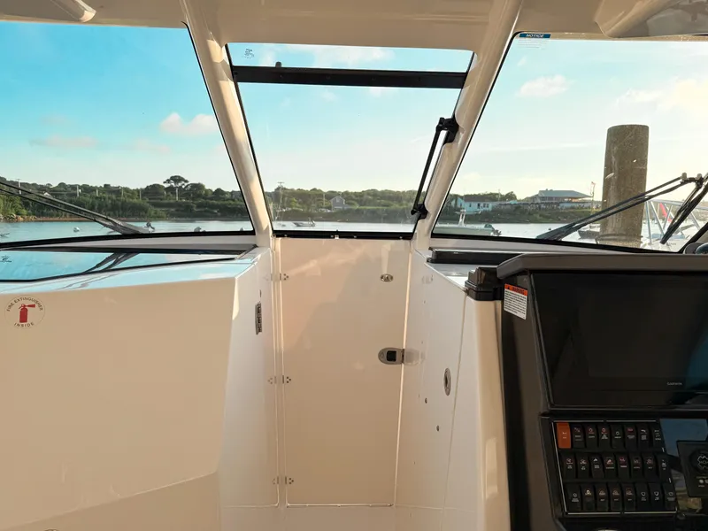 Slide: The Image of 2022 Pursuit DC 365 Dual Console boat interior with dashboard and scenic water view. - 37