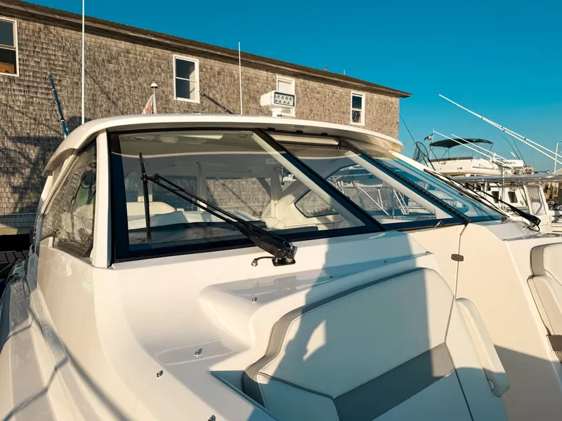 Slide: The Image of 2022 Pursuit DC 365 Dual Console boat docked near a wooden building under clear blue sky. - 39