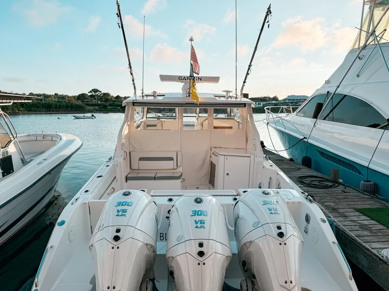 Slide: The Image of 2022 Pursuit DC 365 Dual Console boat docked with triple Yamaha 300 V6 engines. - 4