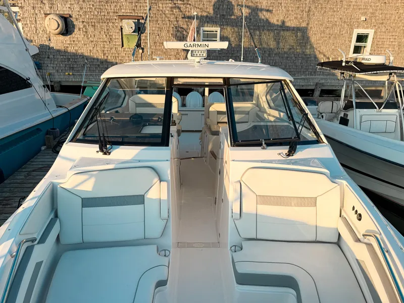 Slide: The Image of 2022 Pursuit DC 365 Dual Console boat docked, showcasing spacious seating and modern design. - 40