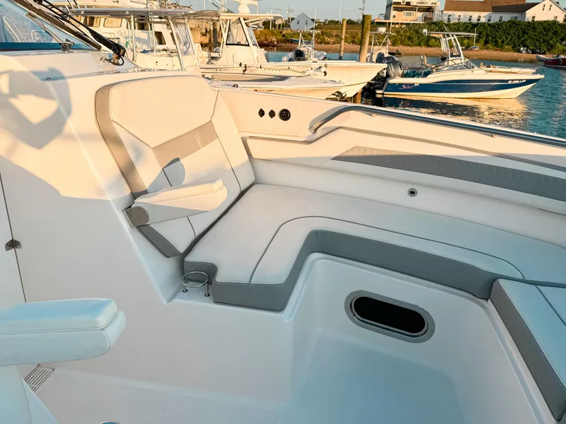 Slide: The Image of 2022 Pursuit DC 365 Dual Console boat interior with cushioned seating and cup holder. - 45