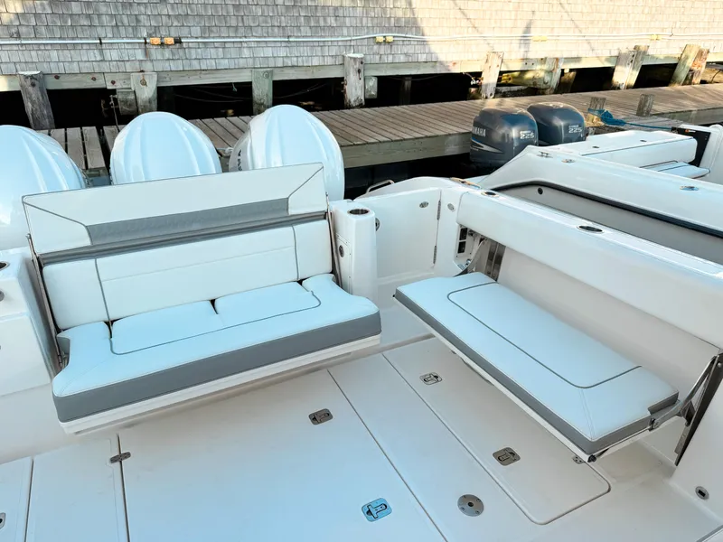 Slide: The Image of 2022 Pursuit DC 365 Dual Console boat with white seating and docked engines. - 9