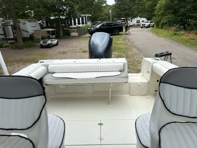 Slide: The Image of 2006 Caravelle Sea Hawk 230 Walk Around boat interior with seating and motor, parked outdoors. - 4