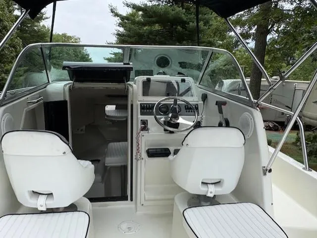 Slide: The Image of 2006 Caravelle Sea Hawk 230 Walk Around boat interior with steering wheel and seating. - 5