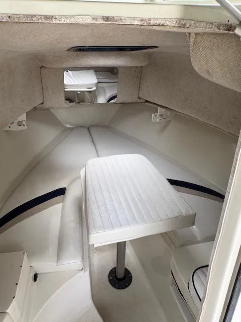 Slide: The Image of 2006 Caravelle Sea Hawk 230 Walk Around cabin interior with seating and table. - 6