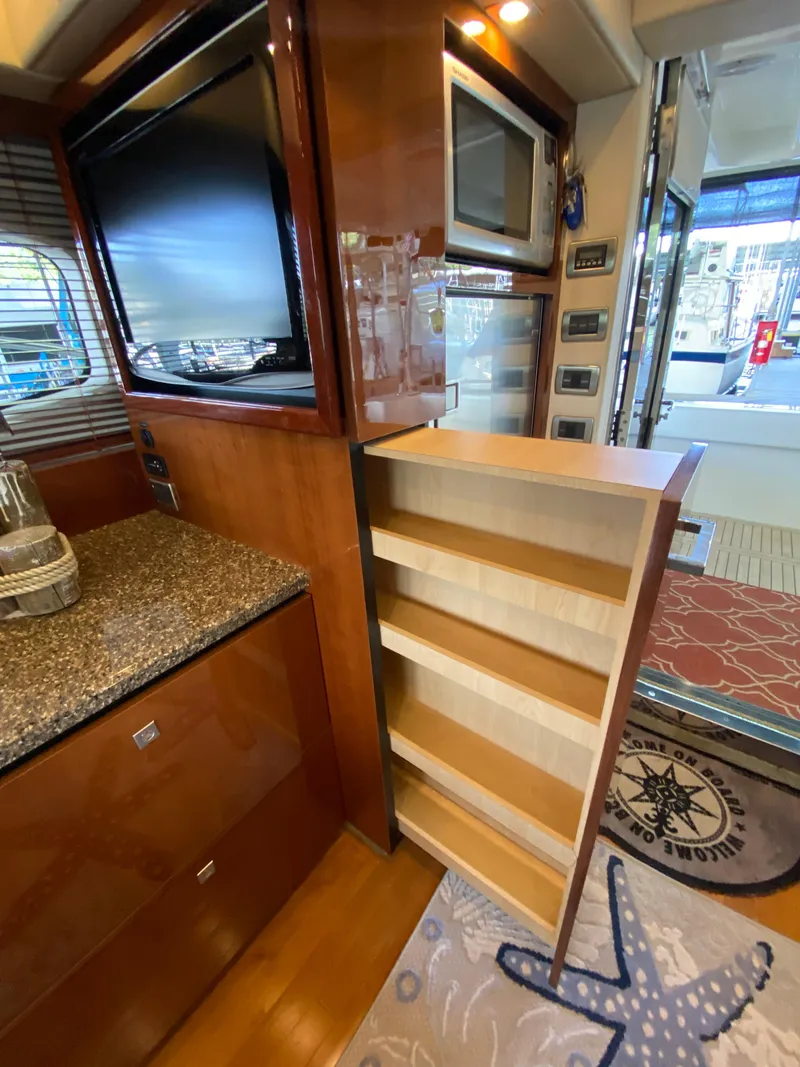 Slide: The Image of Interior of 2008 Sea Ray 47 Sedan Bridge with pull-out storage and modern appliances. - 13