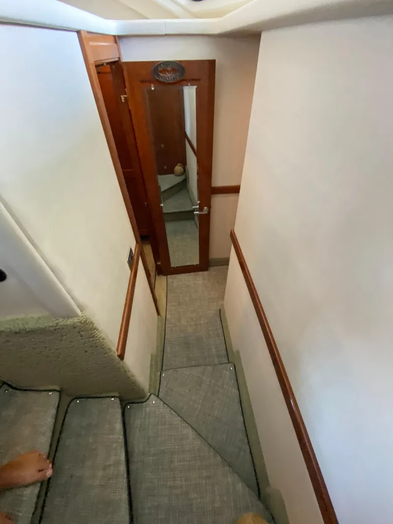 Slide: The Image of Staircase inside 2008 Sea Ray 47 Sedan Bridge yacht with carpeted steps and wooden door. - 19